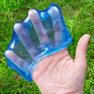 Blue translucent Crazy Aaron's Mega Falling Water putty held in open palm outdoors