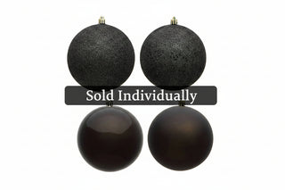 Four black Christmas ball ornaments of different finishes and textures, including glitter, speckled, glossy, and matte, arranged on a plain white background.