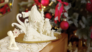 White ceramic Christmas figurine set with Santa and winter characters on decorative base