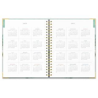 Open spiral planner showing 2026 and 2027 yearly calendar pages with floral cover edges