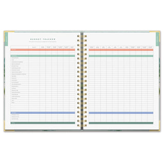 Open spiral planner showing colorful budget tracker pages with income, expenses, and savings rows