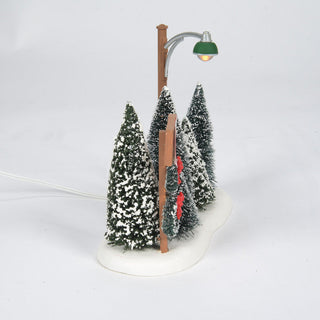 Department 56 miniature Christmas tree lot with snow-covered evergreen trees and vintage street lamp
