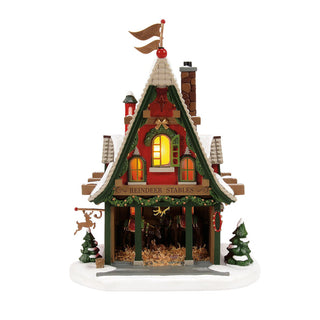 Department 56 Christmas village reindeer stables building with illuminated windows and snow details