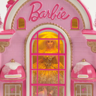 Pink Barbie themed decorative building with arched window displaying doll figure inside