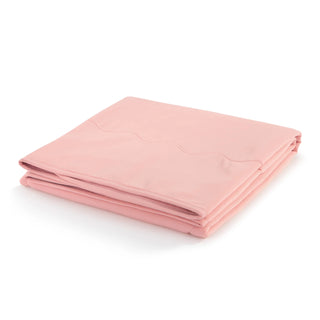 Folded coral pink weighted cooling lap blanket displayed on white background
