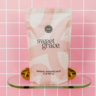 Bridgewater Sweet Grace Mineral Soaking Salts 2 lb bag on glass shelf against pink tile