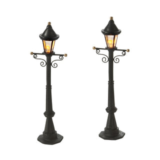 Two black decorative street lamp posts with warm LED lights and ornate scrollwork details