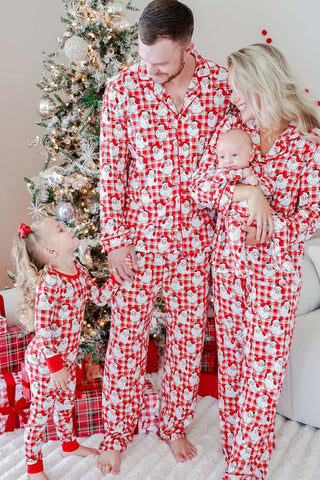Family wearing matching red plaid Santa Claus print Christmas pajama sets near decorated tree