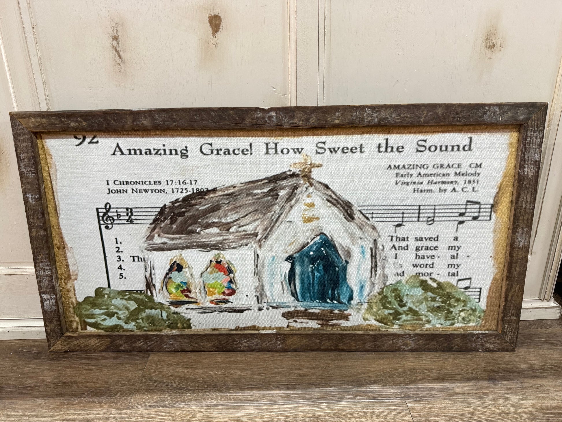 Decorative wall art with a church illustration and 'Amazing Grace' lyrics on a wooden frame.