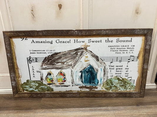 Decorative wall art with a church illustration and 'Amazing Grace' lyrics on a wooden frame.
