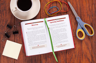 Red textured teacher devotional open to November pages Worry Free and Expressing Thankfulness with green ribbon marker