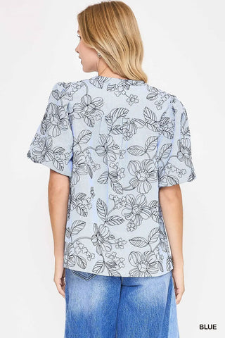 Woman wearing a floral blouse with blue jeans 