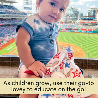 Baby in stadium seat using baseball lovey as educational travel companion