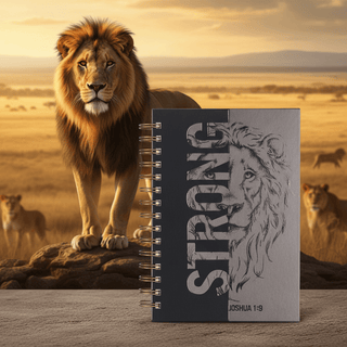 Strong journal with lion illustration and Joshua 1:9, photographed with majestic lions backdrop