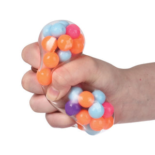Hand squeezing clear mesh stress ball filled with colorful beads spilling out
