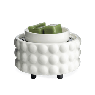 White beaded ceramic wax warmer with green wax melts in top dish on black feet