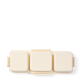 Baby Bento Bogg in Coconut cream color, top-down view showing three compartment lids