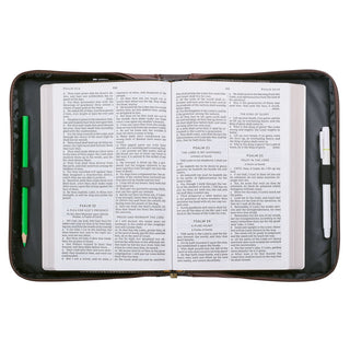 Open Bible inside brown zippered Bible cover showing Psalms 21-25 pages with pen