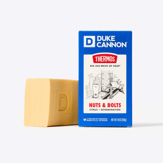 Duke Cannon Nuts and Bolts 10oz Big Ass Brick of Soap beside its blue Thermos-branded packaging