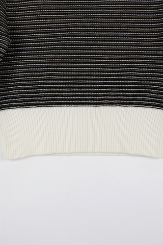 Black and white striped knit pullover sweater with cream ribbed hem