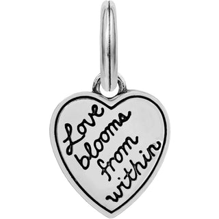Back of Brighton love-themed heart charm engraved with 'Love blooms from within' in black cursive