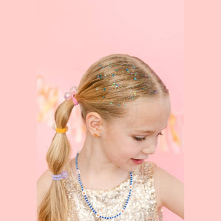 Close-up of blue star-shaped glitter particles on blonde ponytail near parting