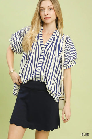 Woman wearing a blue and white striped blouse with a black skirt 