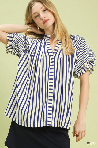 Woman wearing a blue and white striped shirt against 