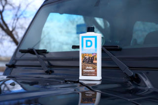 Duke Cannon Jeep Edition American Legend Body Wash bottle placed on hood of black Jeep