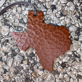 Texas-shaped cognac leather air freshener pendant with embossed cheetah print pattern on leather cord