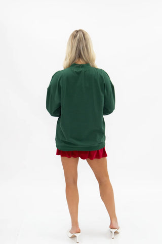Oversized forest green crew neck sweatshirt styled with red satin mini shorts