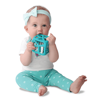 Infant chewing on light blue open-frame silicone chew cube with internal die and tactile edges