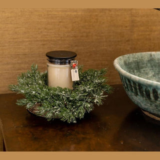 Unlit Bridgewater Comfort & Joy candle styled in pine wreath on rustic wood for Christmas decor