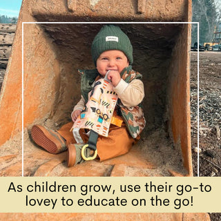 Baby in excavator bucket holding peach construction lovey with yellow minky back