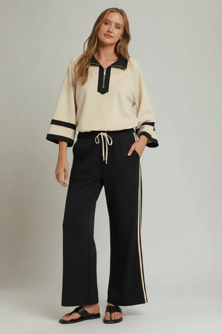 Black wide-leg pants with cream side stripes and drawstring waist