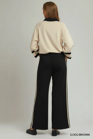Black wide-leg pants with cream side stripes, shown from back view