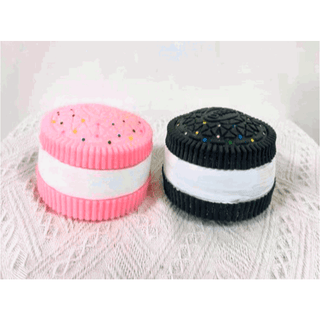 Cookie-shaped squishy fidget toys in pink and black colors with demonstration hands