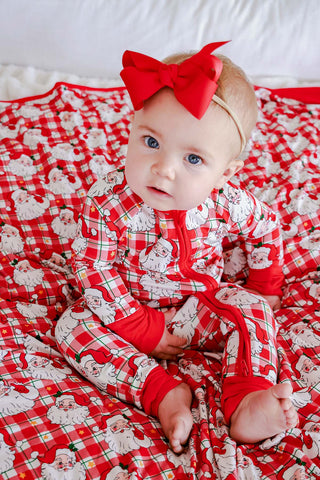Baby girl wearing Caden Lane Cozy Claus Santa plaid Christmas bamboo zipper romper with matching blanket