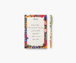 Rifle Paper Co. Curio floral pen displayed alongside a matching floral notepad on white background