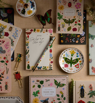 Rifle Paper Co. Curio pen styled with botanical stationery collection flatlay on linen background
