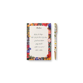 Rifle Paper Co. Curio floral pen beside a colorful floral notepad with handwritten notes list