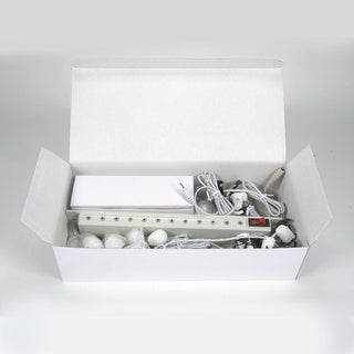 Department 56 lighting system kit in open white box with bulbs, wires, and power strip