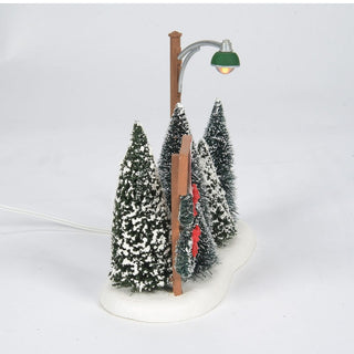 Department 56 miniature Christmas tree lot with snow-covered evergreen trees and vintage street lamp
