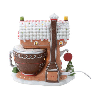 Front view of Department 56 Piper's Piping Academy lighted building showing glowing windows and piped icing details