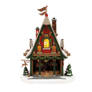 Department 56 Christmas village reindeer stables building with illuminated windows and snow details