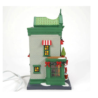 Back-right angle of Department 56 Santa's Corner Confectionery with visible power cord and snow-dusted roof