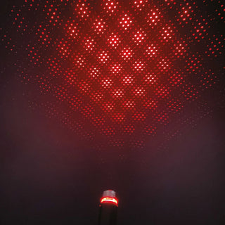 Red laser star projector casting hundreds of red light dots across dark ceiling
