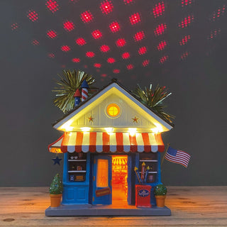 Department 56 lit patriotic fireworks shop figurine projecting red starlight patterns overhead