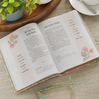Open pink faux leather devotional book showing March entries with floral accents on wooden surface