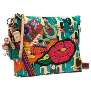 Side angle of Consuela Dezi crossbody showing structured shape, gold horseshoe detail, and layered floral embroidery